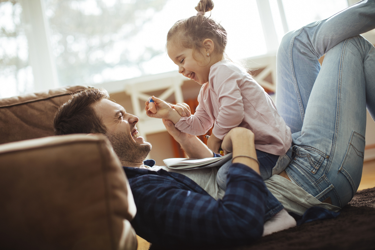 pappa och liten dotter leker på golvet 