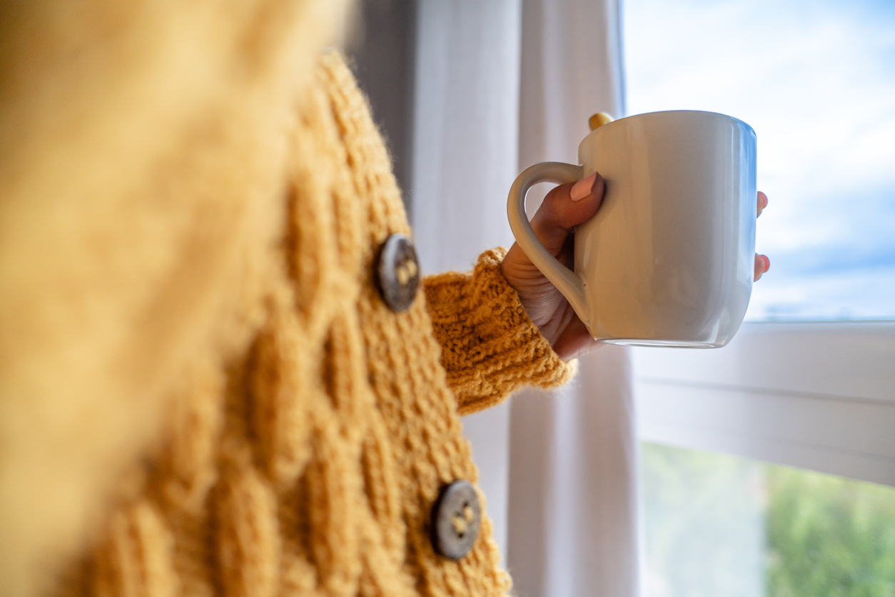 En kvinnas hand som håller i en kopp 