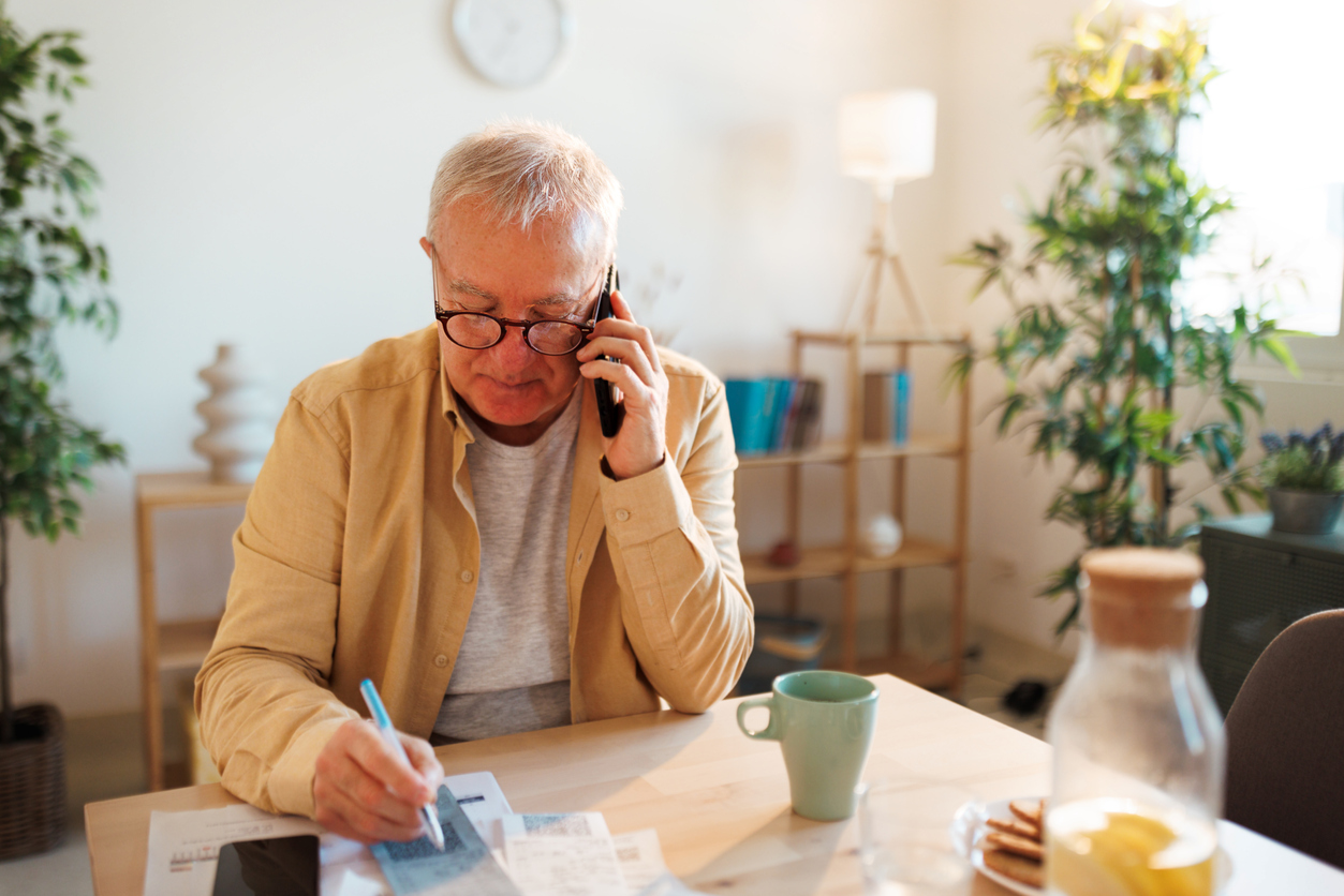 Man som sitter i telefon och betalar räkningar