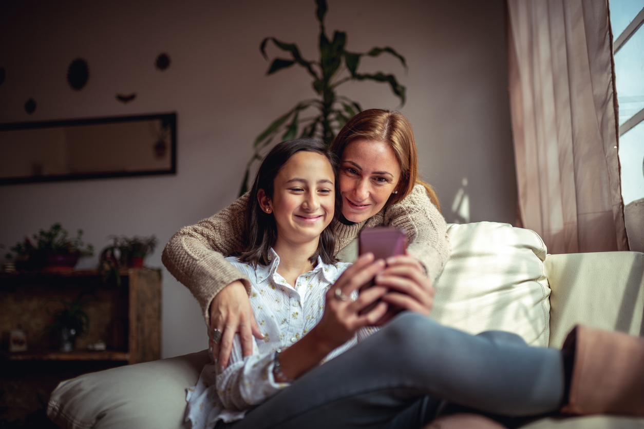 Mor och dotter tar en selfie i en soffa