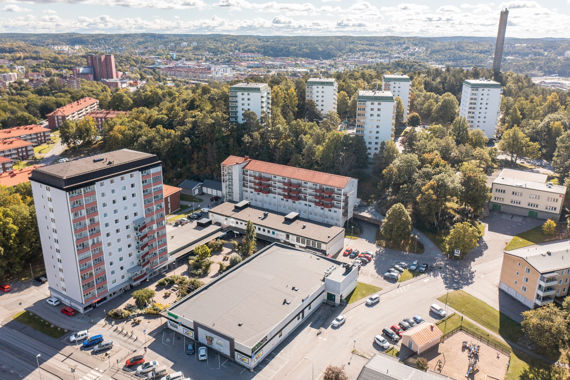 Flygbild på fastigheten adress Sunnanvindsvägen 8 i mitten av bilden med vy mot centrum.