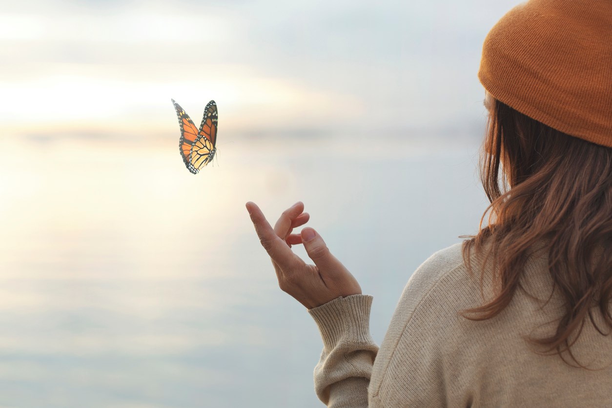 Kvinna som ser en fjäril flyga iväg