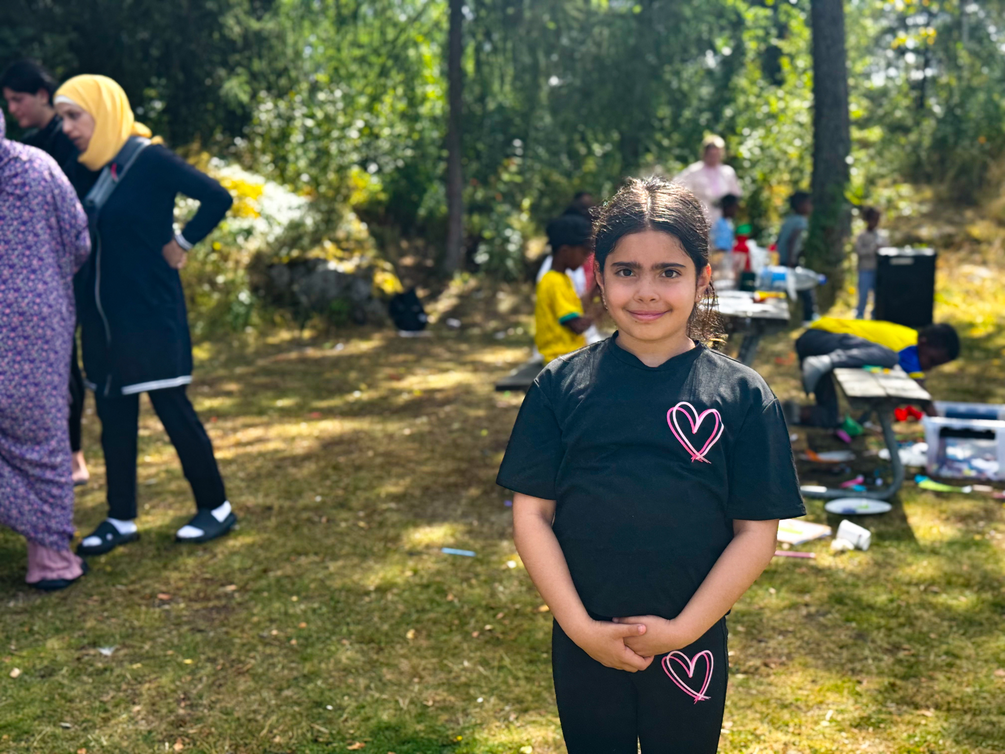 Tjej som ler in i kameran med människor i bakgrunden