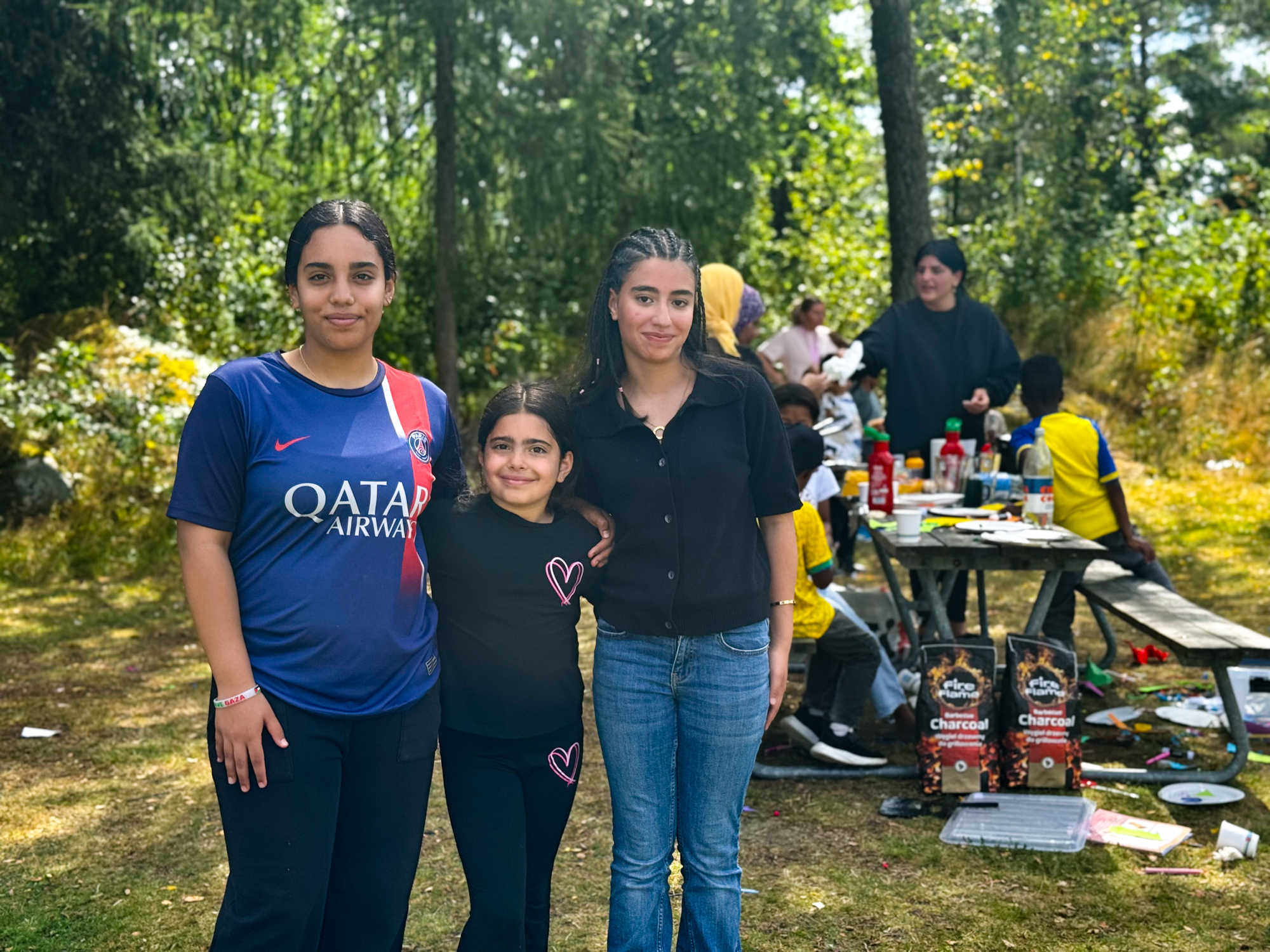 Tre tjejer som poserar framför kameran och håller om varandra